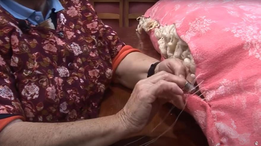 Cosido manual de un colchón de lana durante su reparación y mantenimiento artesanal