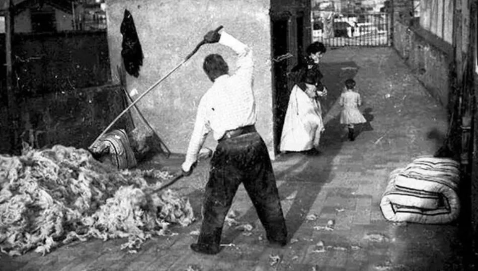 Vareado tradicional de lana para la renovación de colchones en un entorno urbano